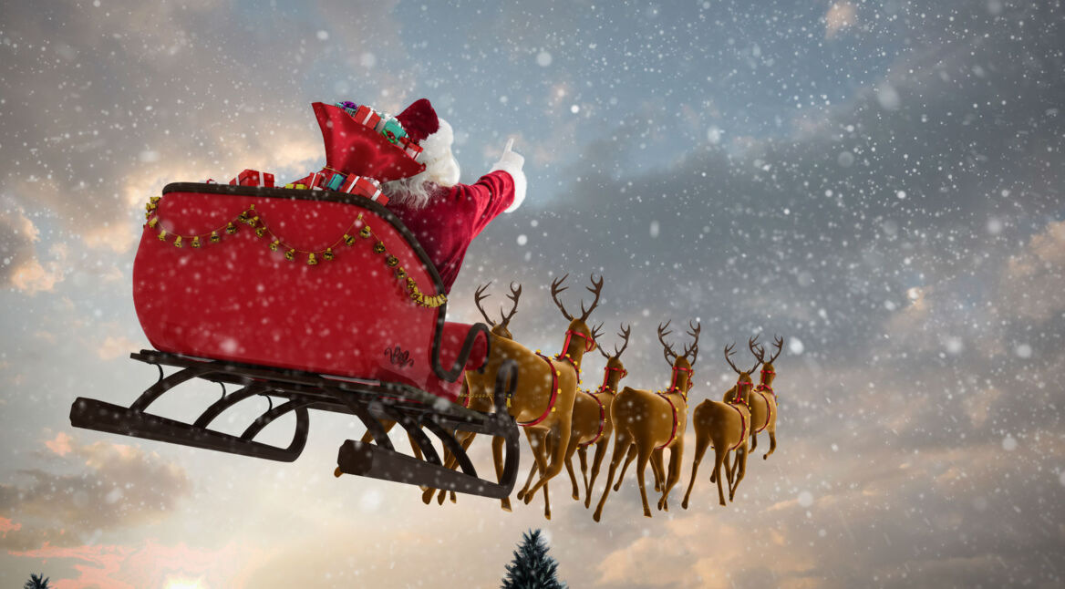 Weihnachtsmann fliegt im Schlitten mit seinen Rentieren durch die Nacht.