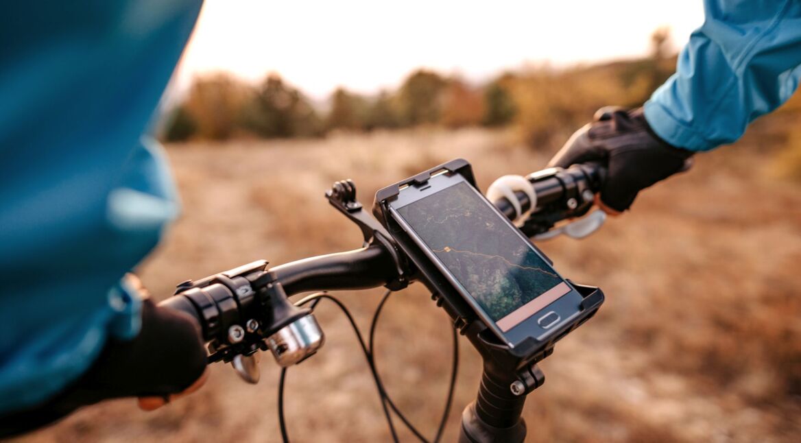 Radfahrer nutzt Fahrrad-Navi-App am Handy.