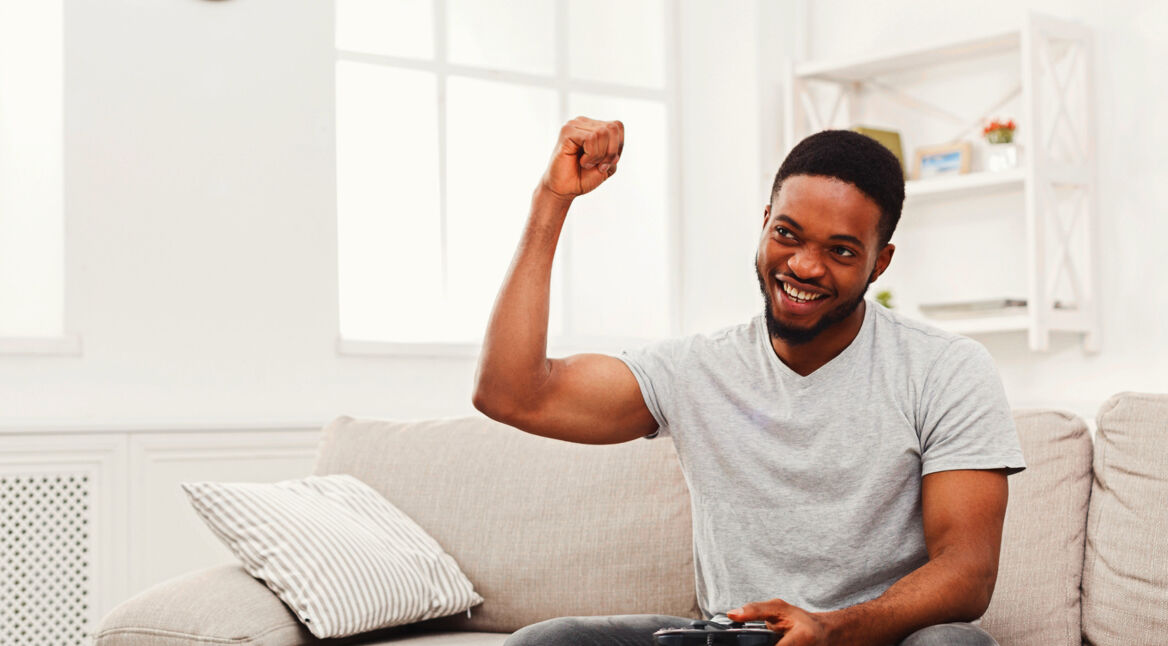 Junger Mann zockt mit PS4-Controller.