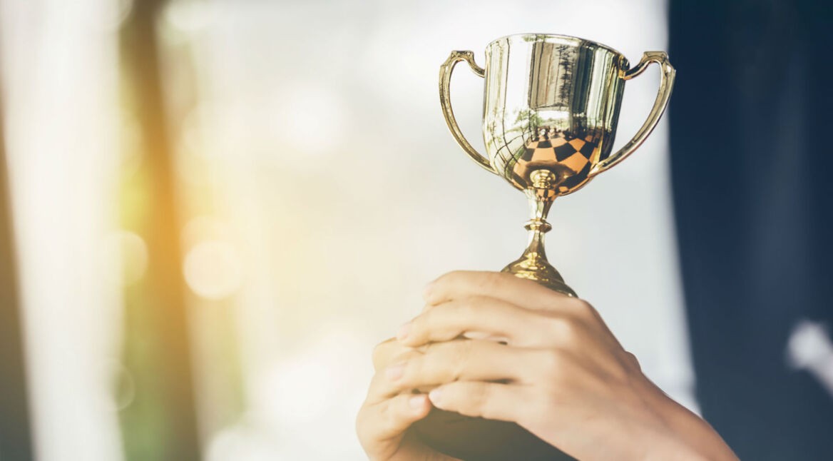 Trophäe in der Hand halten.