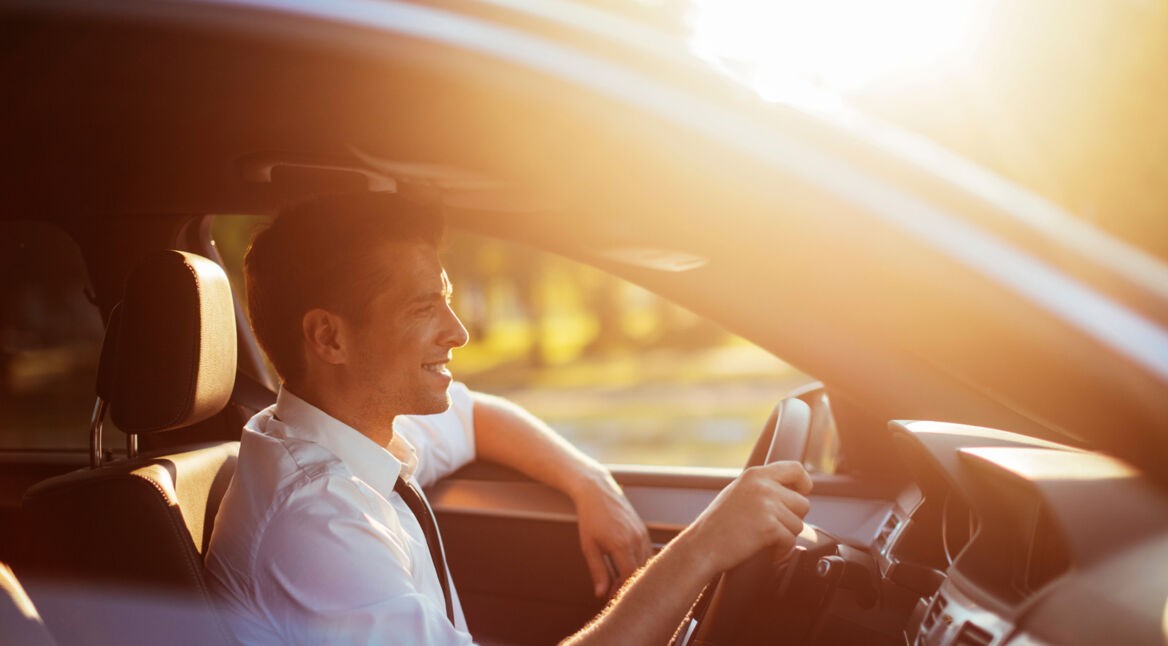 Junger Mann beim Fahren unterhält sich mit Amazon Alexa