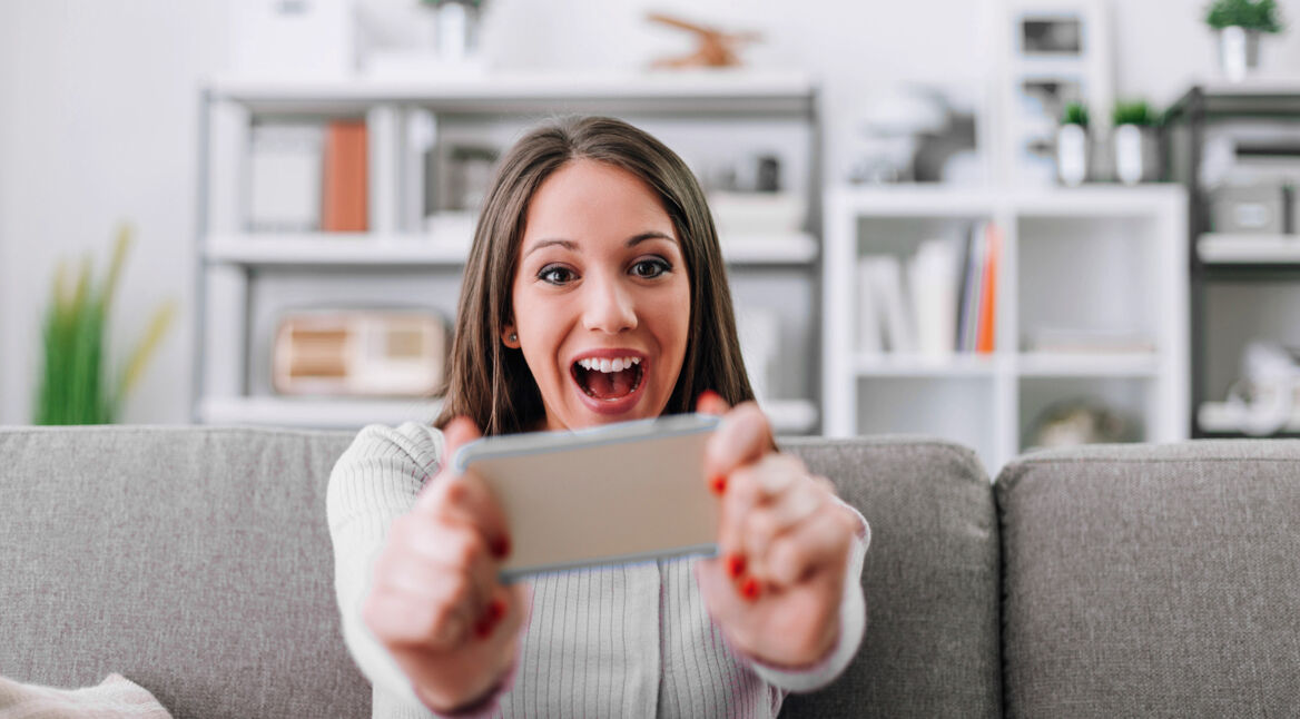 Eine Frau steuert ein Spiel via Smartphone