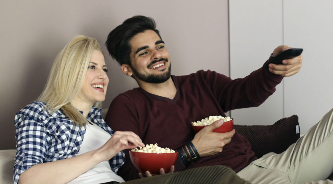 Paar verbringt den Abend auf dem Sofa und schaut Filme.