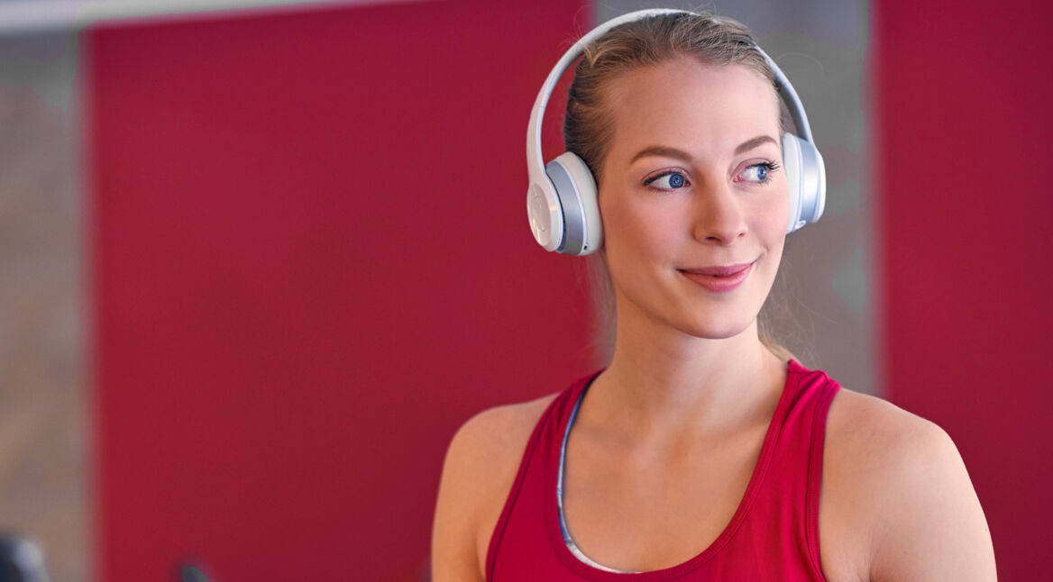 Frau auf dem Laufband hört Musik über ihre Smartwatch.