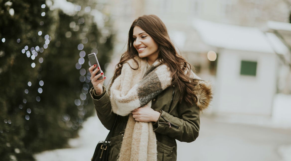 Junge Frau aktualisiert ihr Smartphone.