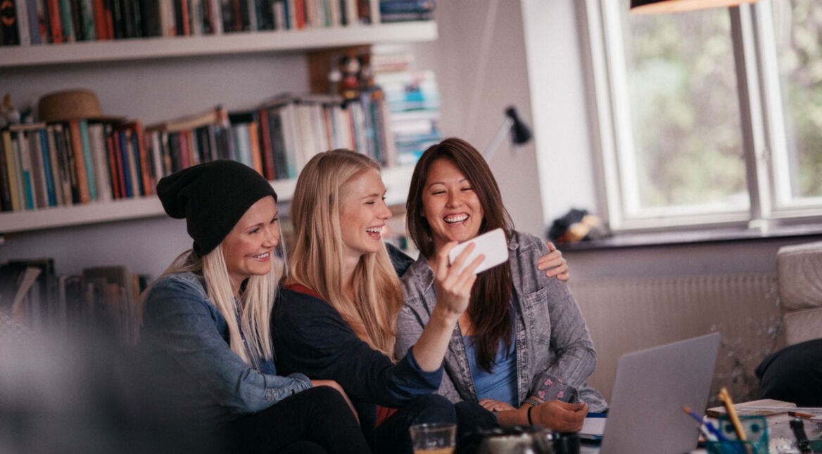 Freundinnen schauen YouTube-Videos am Smartphone.