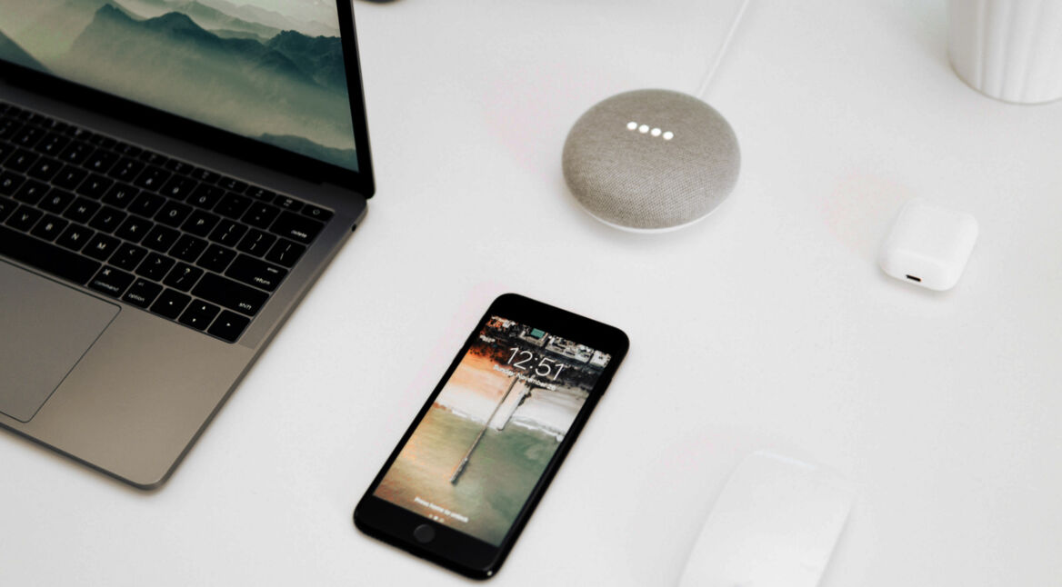 Google Smart Home Mini, ein Laptop und ein Smartphone