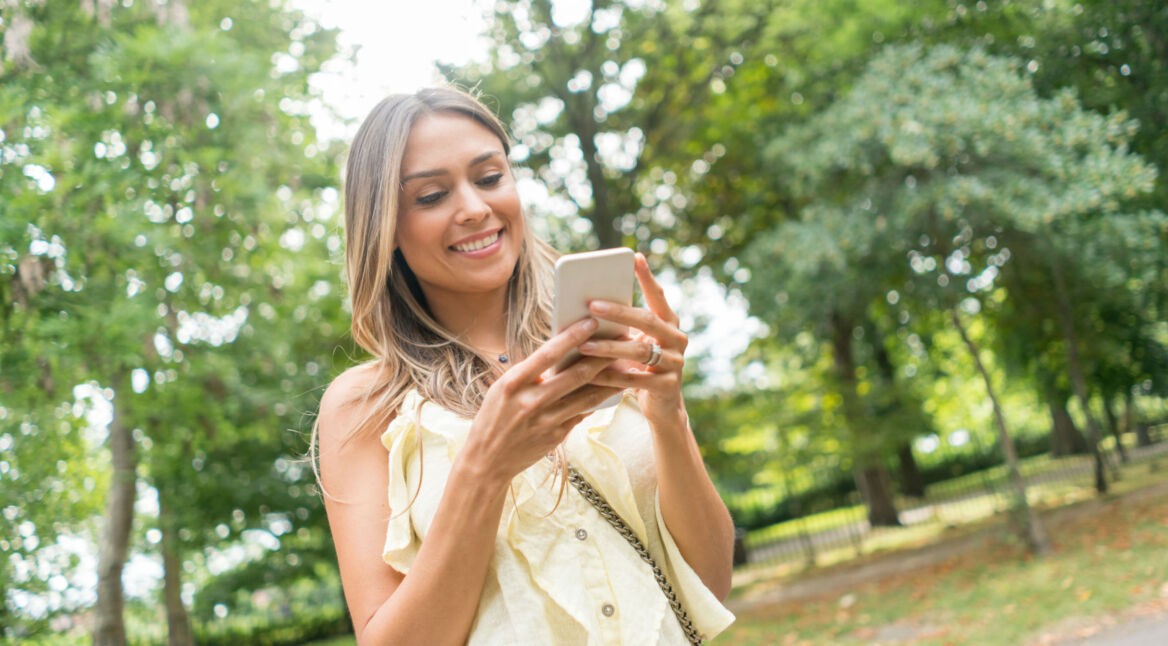 Junge Frau spielt ein Adventure-Game auf ihrem Smartphone.