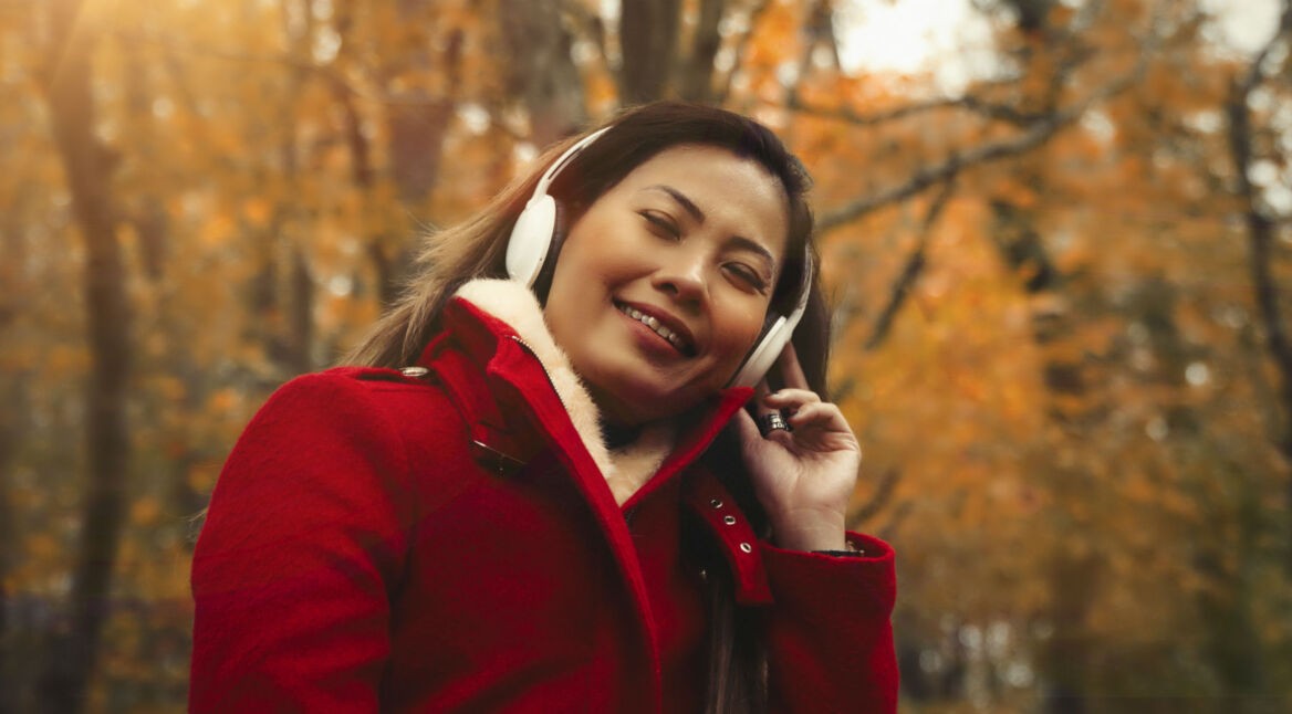 Junge Frau hört Musik über ihre Kopfhörer.