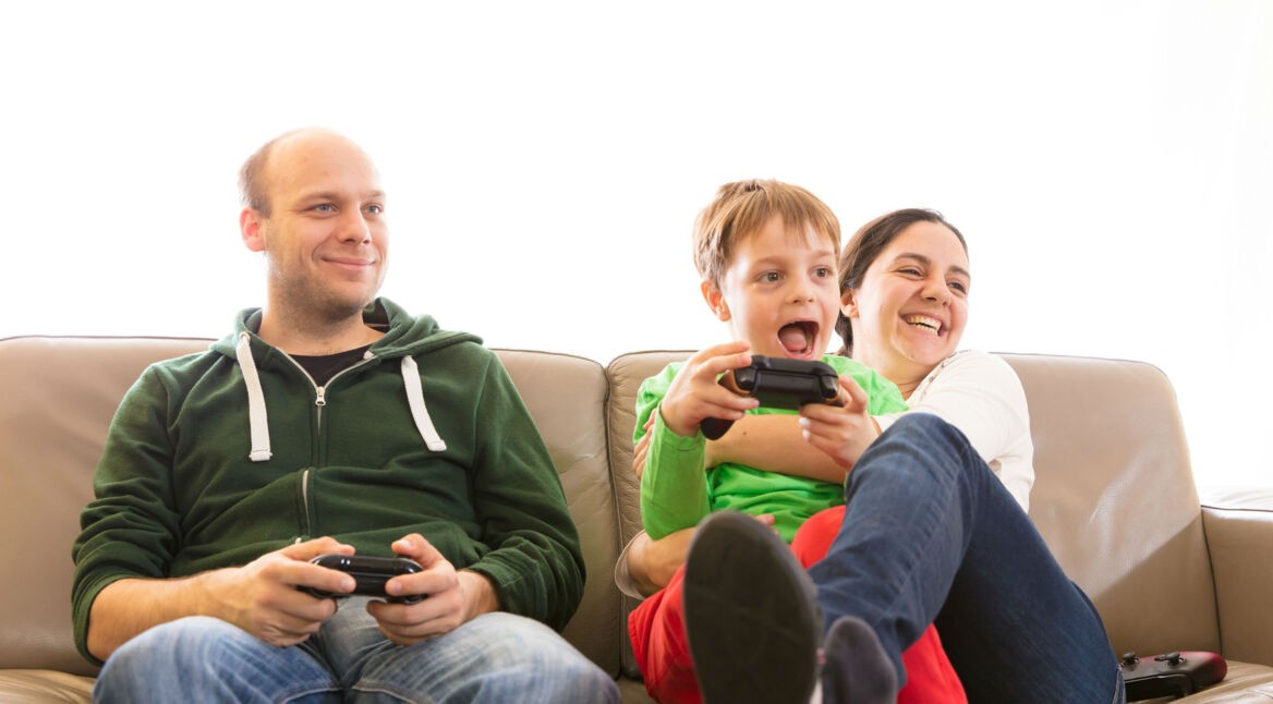 Familie zockt von der Couch aus mit Xbox-Controllern.