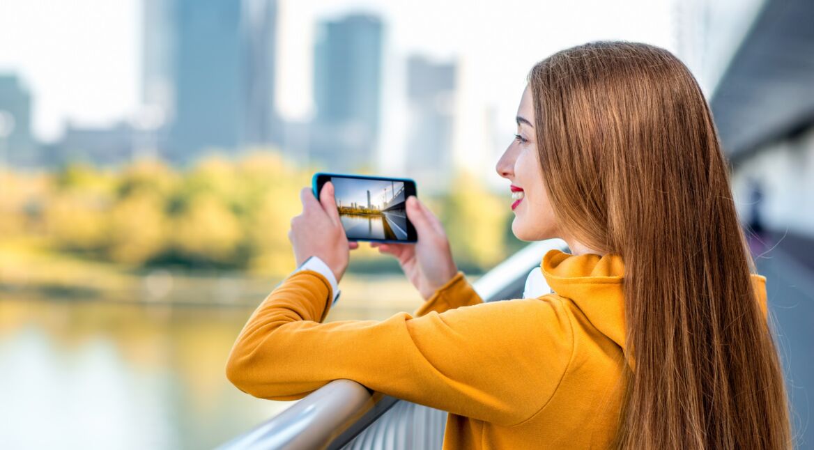 Junge Frau schießt Foto von Hochhäusern