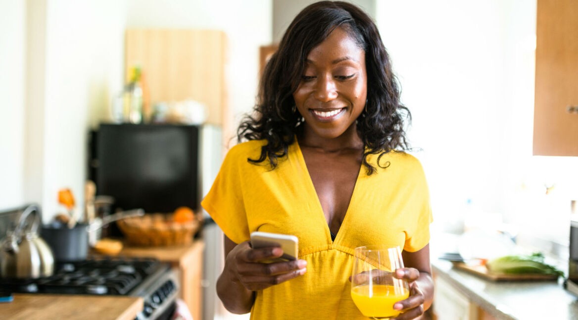 Junge Frau spielt Final Fantasy XV am Smartphone.