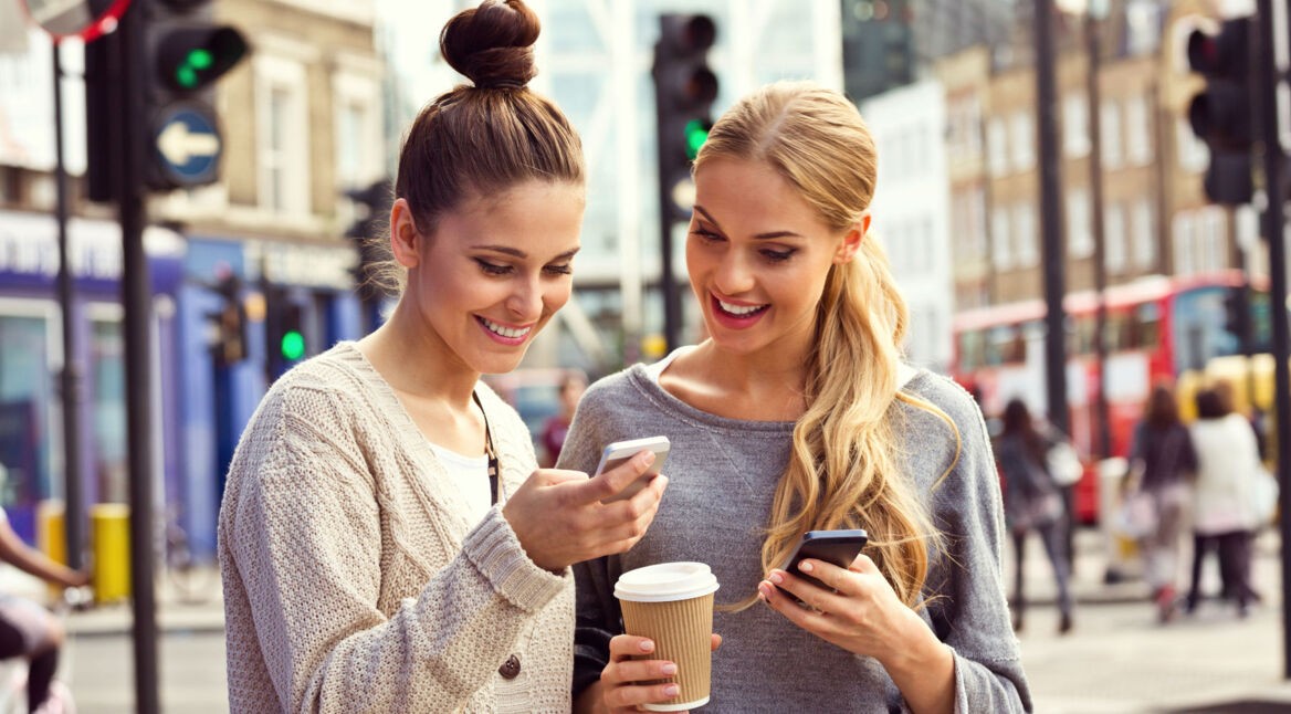 Freundinnen nutzen den Facebook Messenger auf ihren Smartphones.