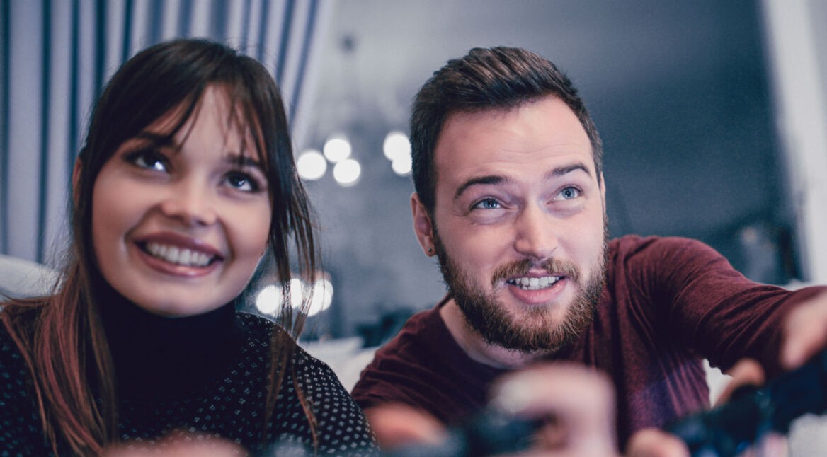 Junges Paar zockt über die Konsole.