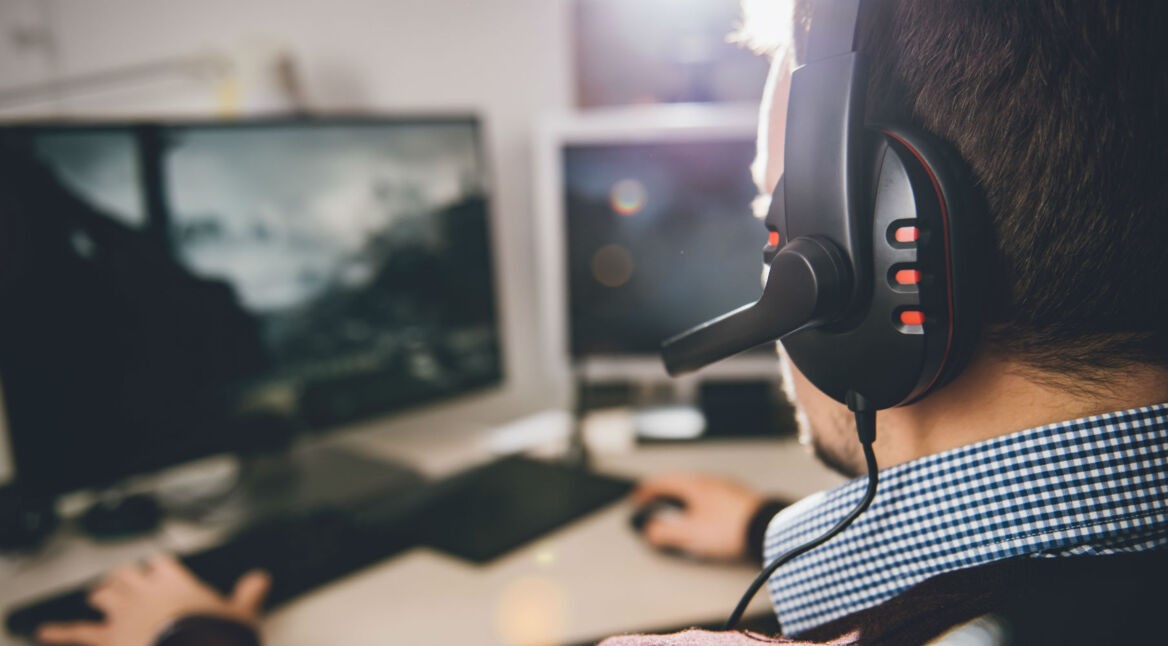 Junger Mann spielt die PC-Fassung von Final Fantasy XV am Computer.