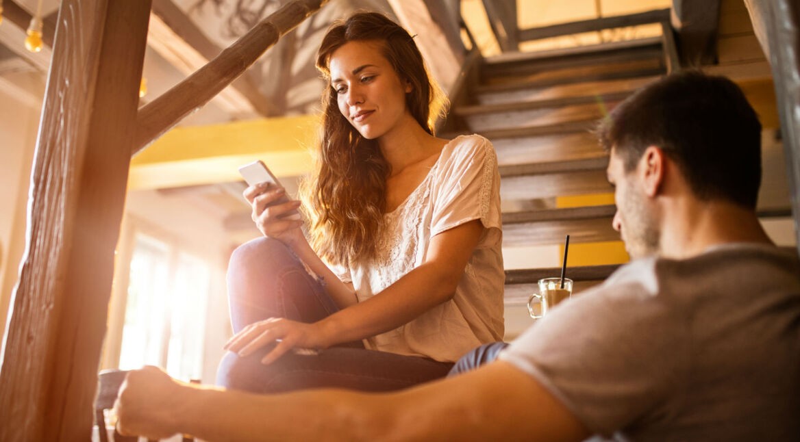 Junge Frau nutzt Google Assistant an ihrem Smartphone.