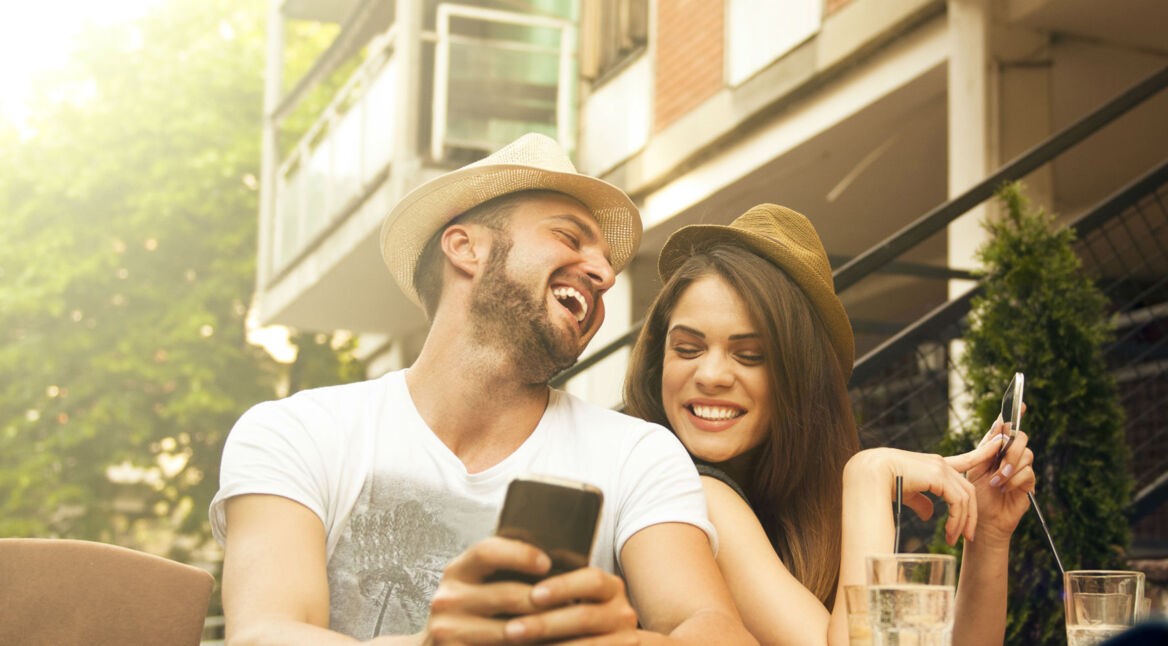 Junges Paar spielt Mario Kart übers Smartphone.