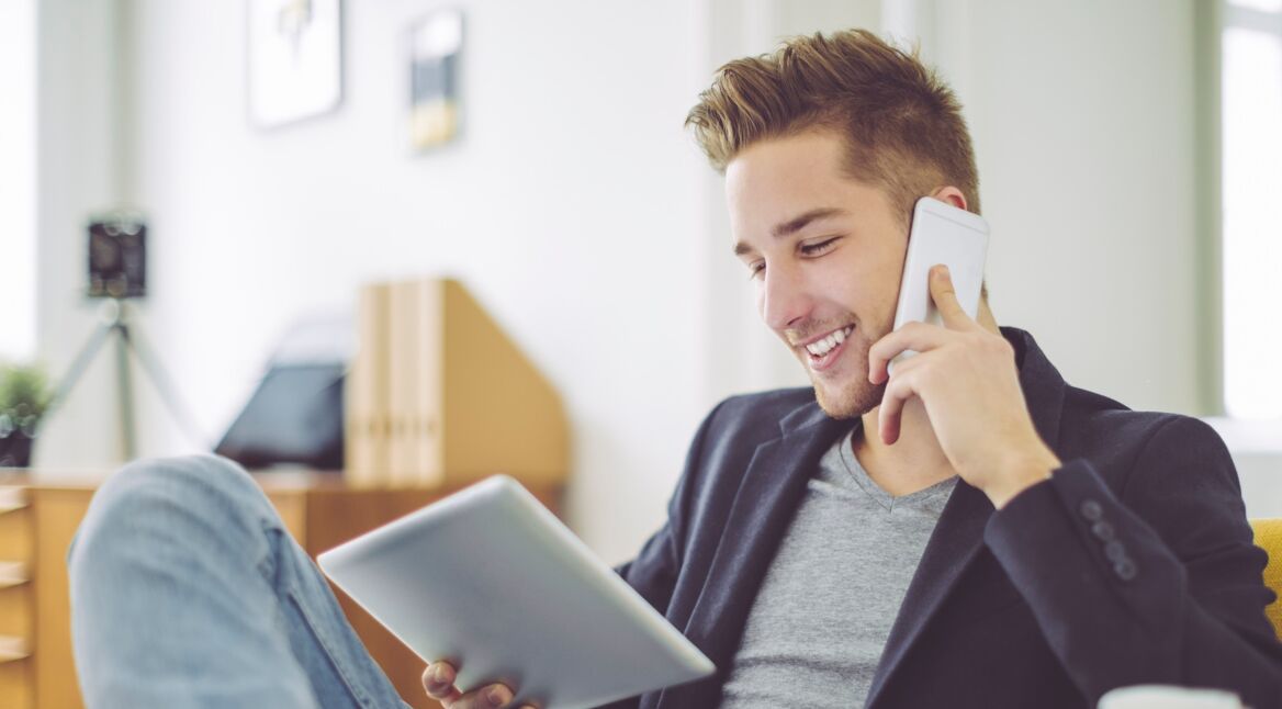 Mann Home Office mit Tablet und Smartphone