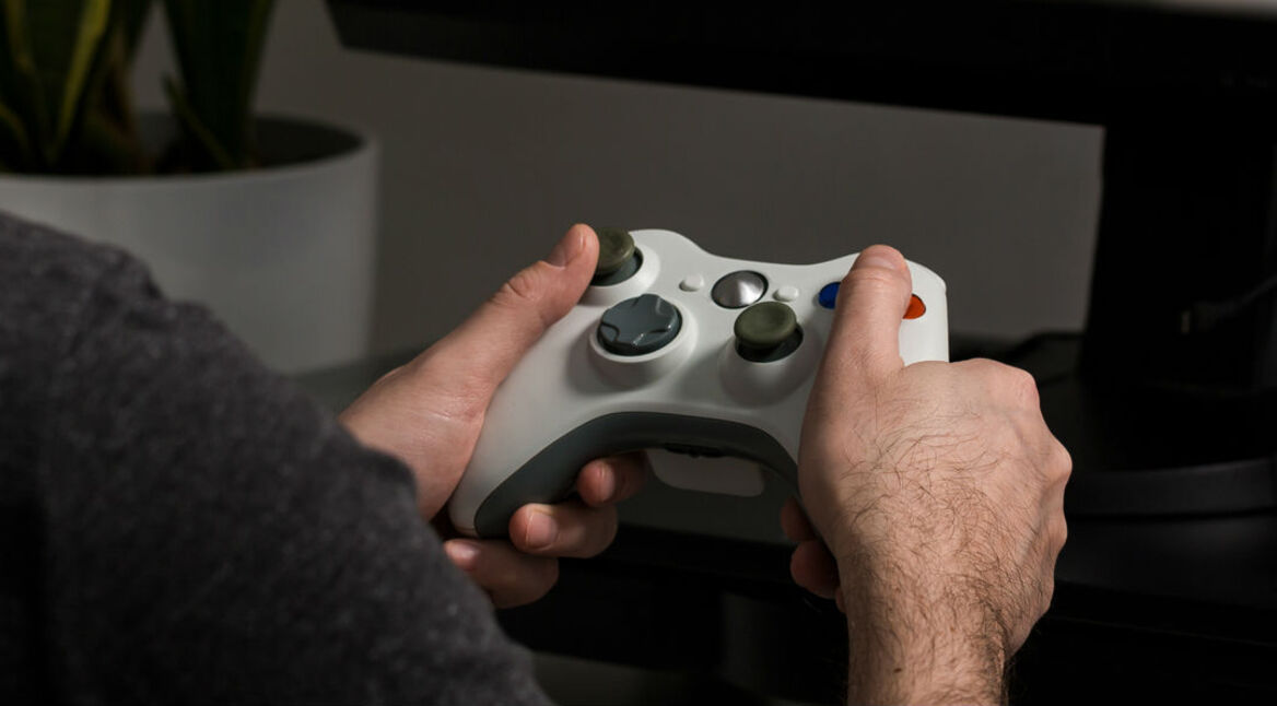 Junger Mann spielt ein Multiplayer-Game mit dem Xbox-Controller.
