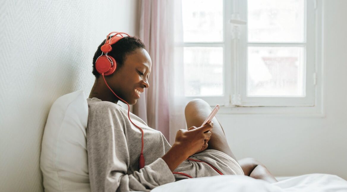 Woman-with-headphones-in-bed_1920