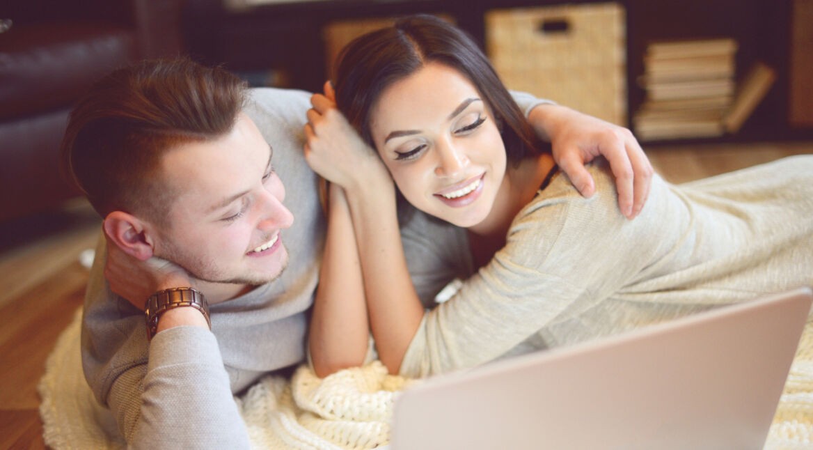 Glückliches Paar schaut Netflix-Streams auf dem Laptop