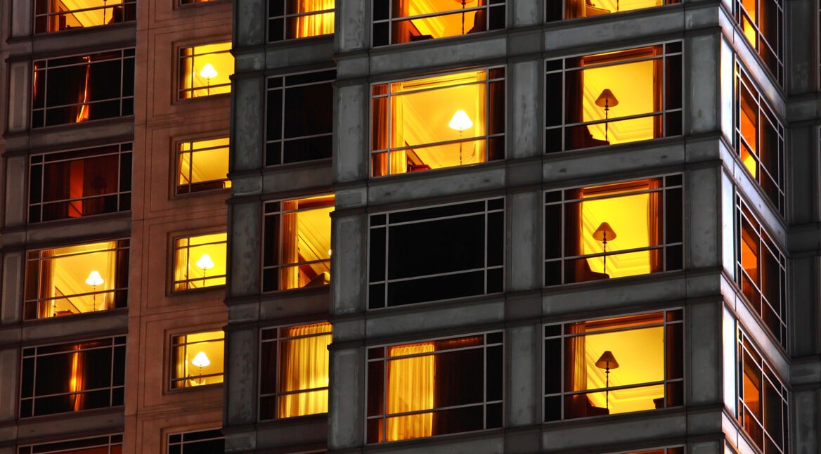 Ansicht eines Hochhauses mit identischen Lampen in den Zimmern