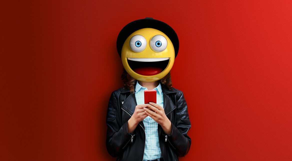 Fashion woman is using smartphone in black rock jacket on colorful orange background