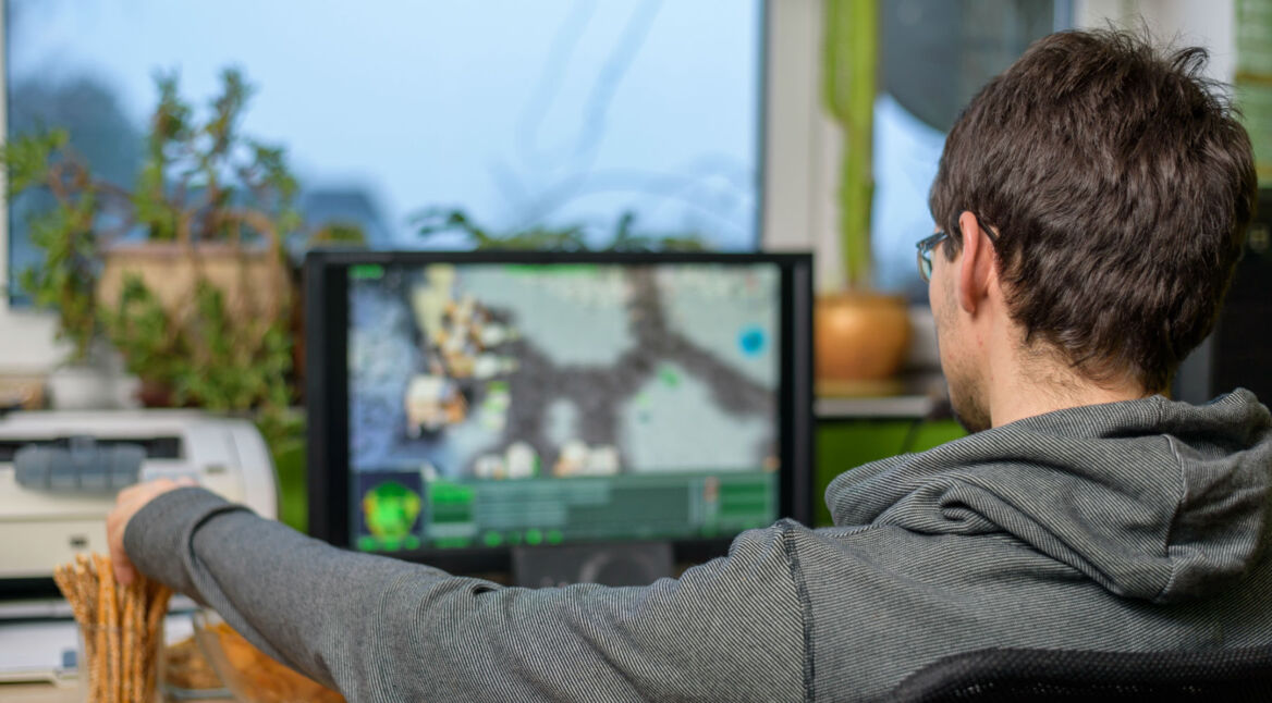 Junger Mann spielt Battle Royale-Games auf seinem PC.