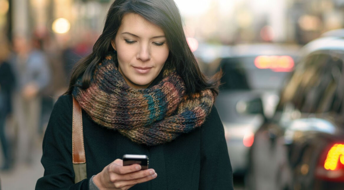 Junge Frau nutzt den Google Kalender auf ihrem Smartphone.