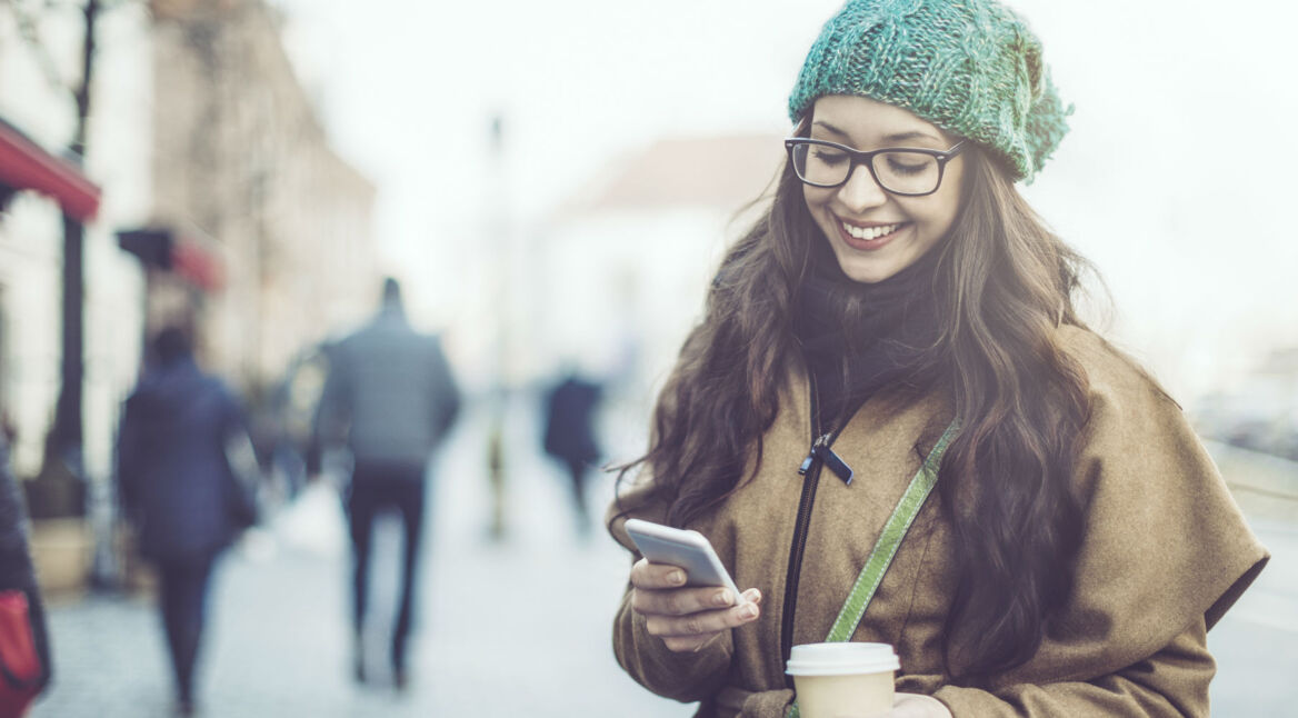 Junge Frau verwendet den Dark Mode in der YouTube-App auf ihrem Smartphone.