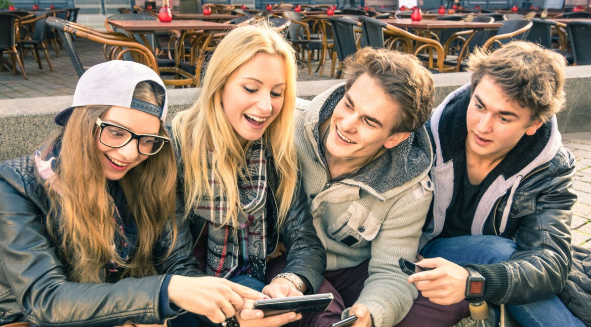 Vier Freunde spielen Westworld am Smartphone.