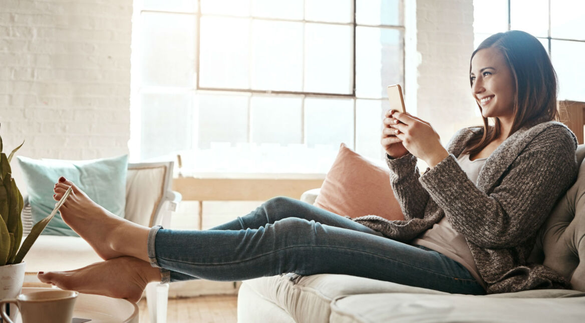 Junge Frau surft am Smartphone bei Instagram.