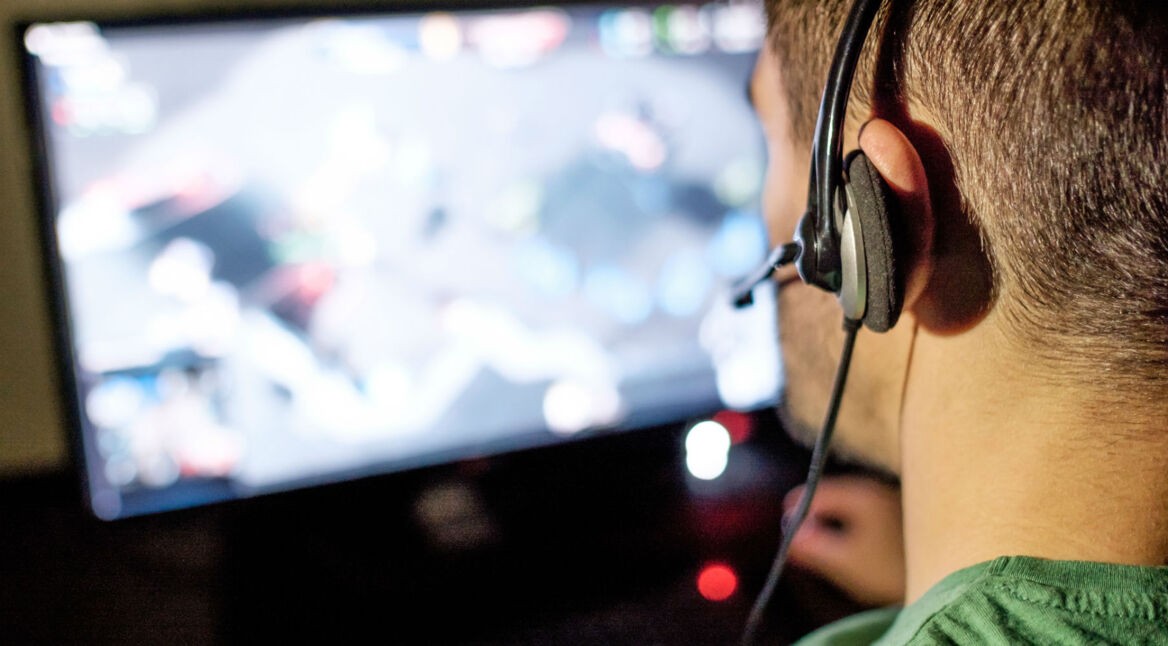 Mann zockt am Computer seine PC-Spiele.