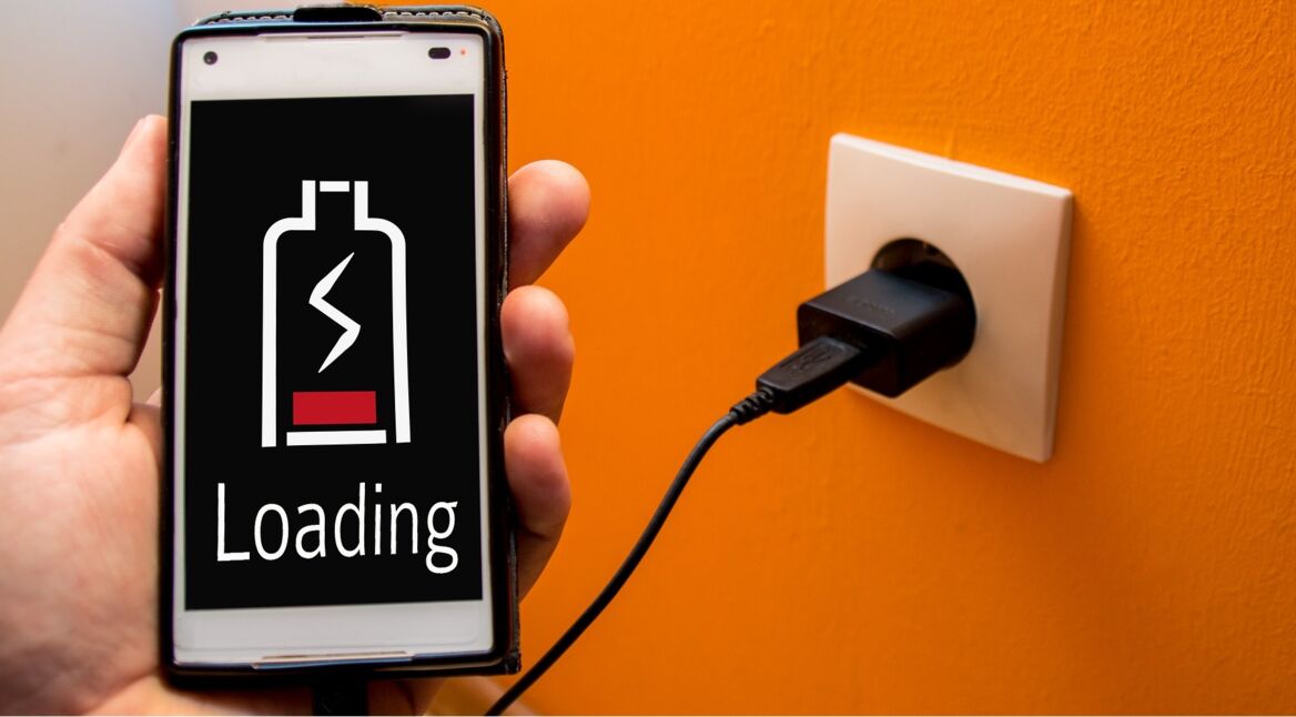 Ein Smartphone wird mittels eines Ladegerätes geladen.