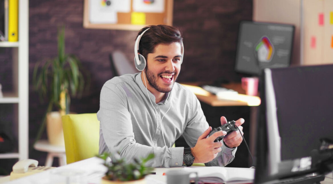 Mann zockt MMO-Spiel an seinem PC mit PS4-Controller.