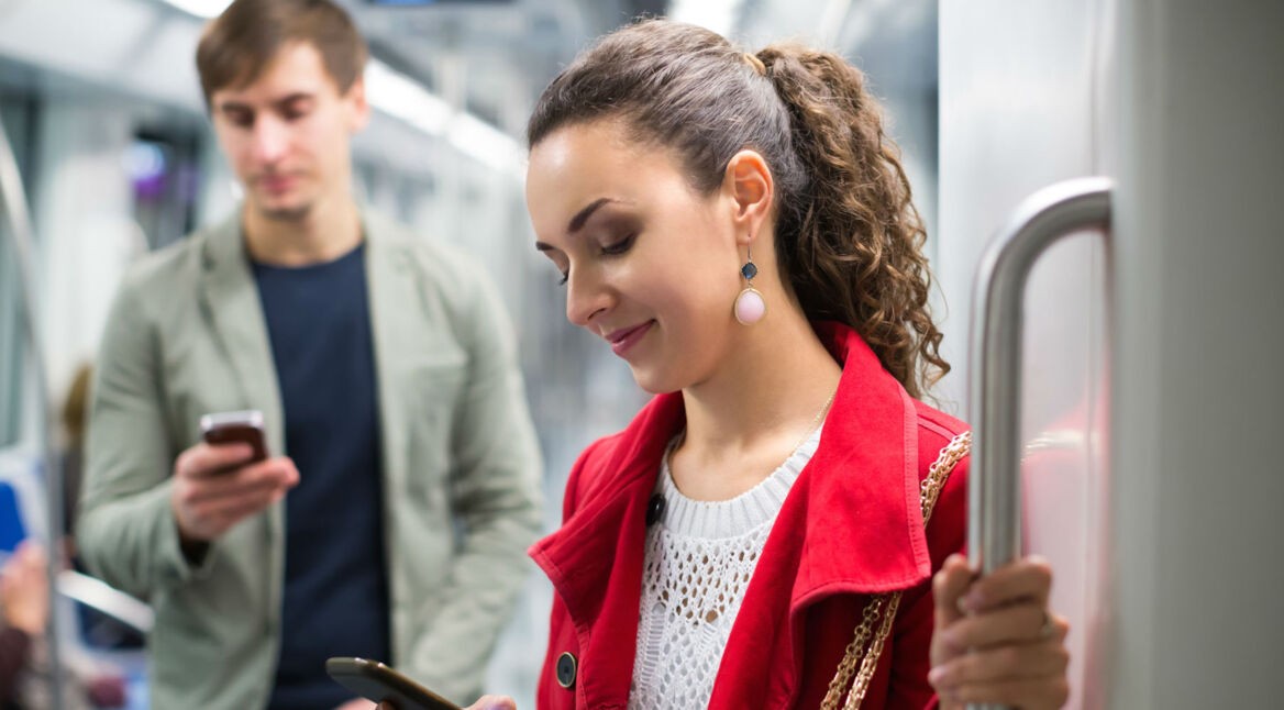 Junge Frau schaut Instagram-Fotos auf dem Smartphone an.