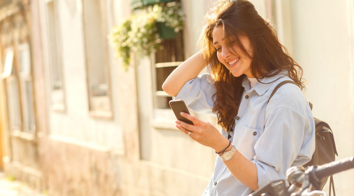 Junge Frau schaut YouTube-Videos am Smartphone.