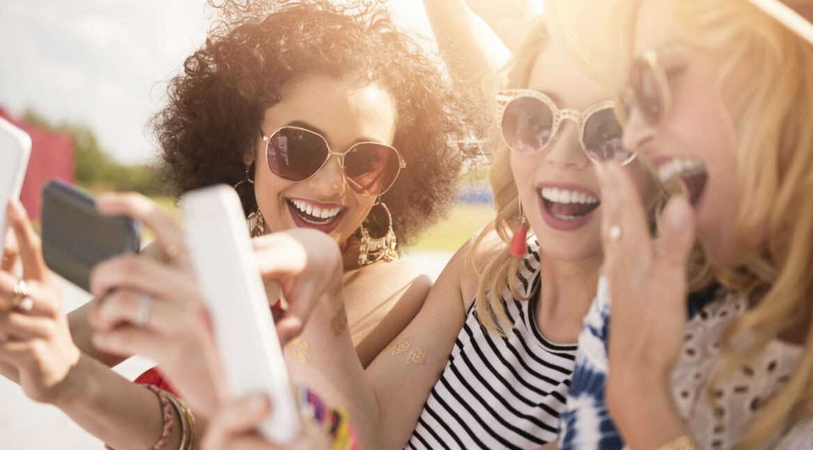 Freundinnen verwenden die Instagram-App auf dem Smartphone.