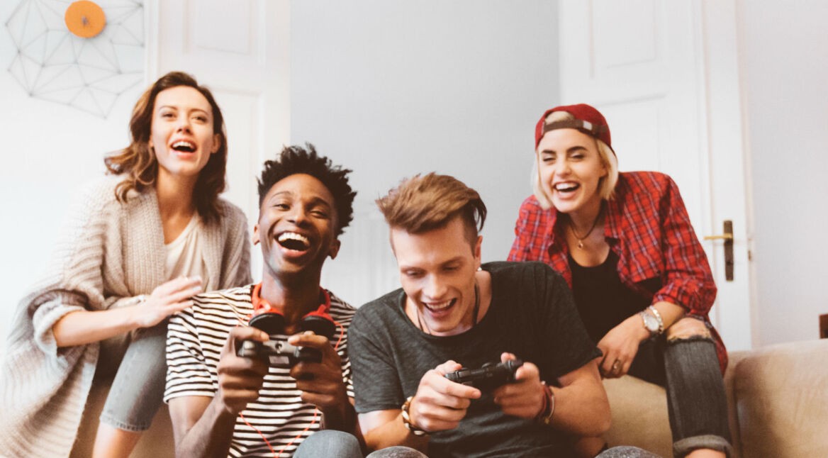 Freunde zocken Anime-Spiele von der Couch aus.