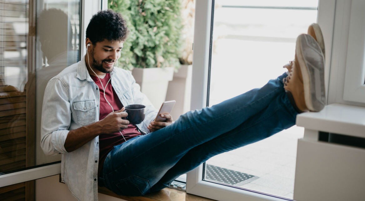 Junger Mann zockt via Smartphone.