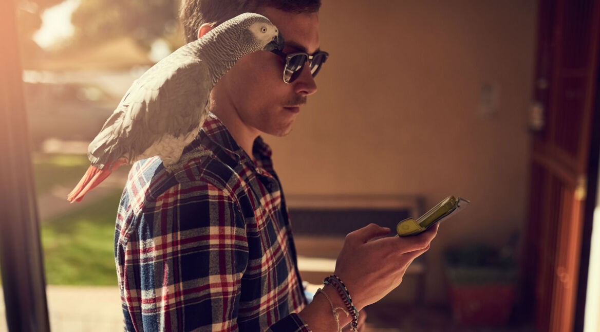 Junger Mann sperrt In-App-Käufe auf seinem Smartphone.