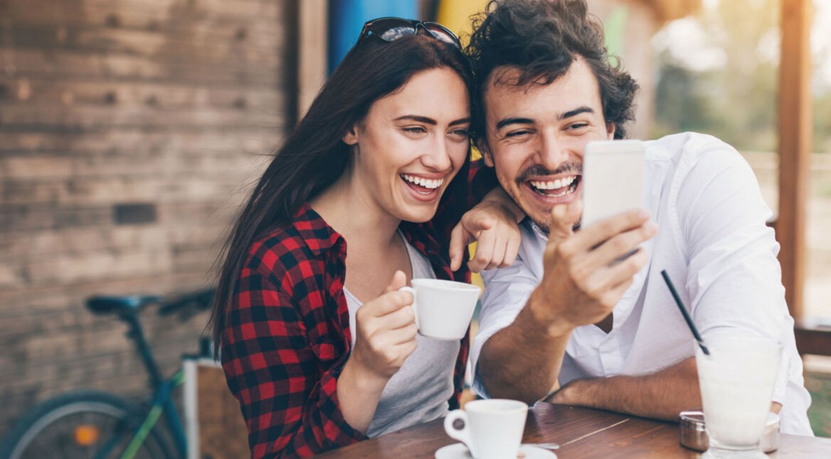 Junges Paar verwendet WhatsApp am Smartphone.