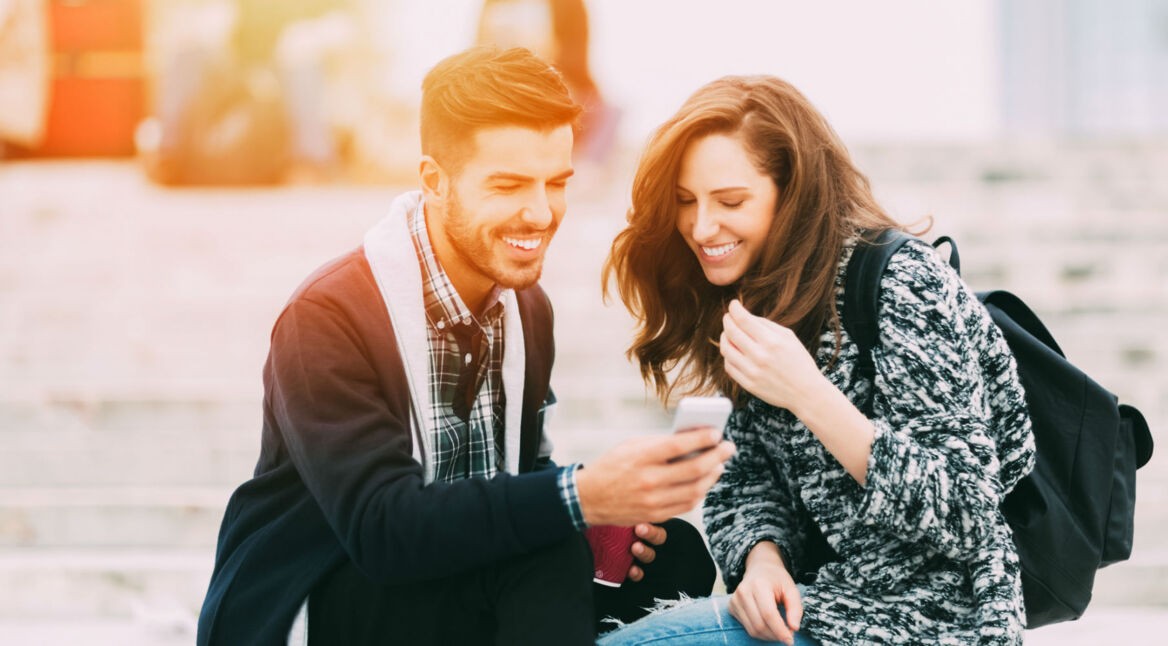 Zwei Freunde schauen YouTube-Video am Smartphone.