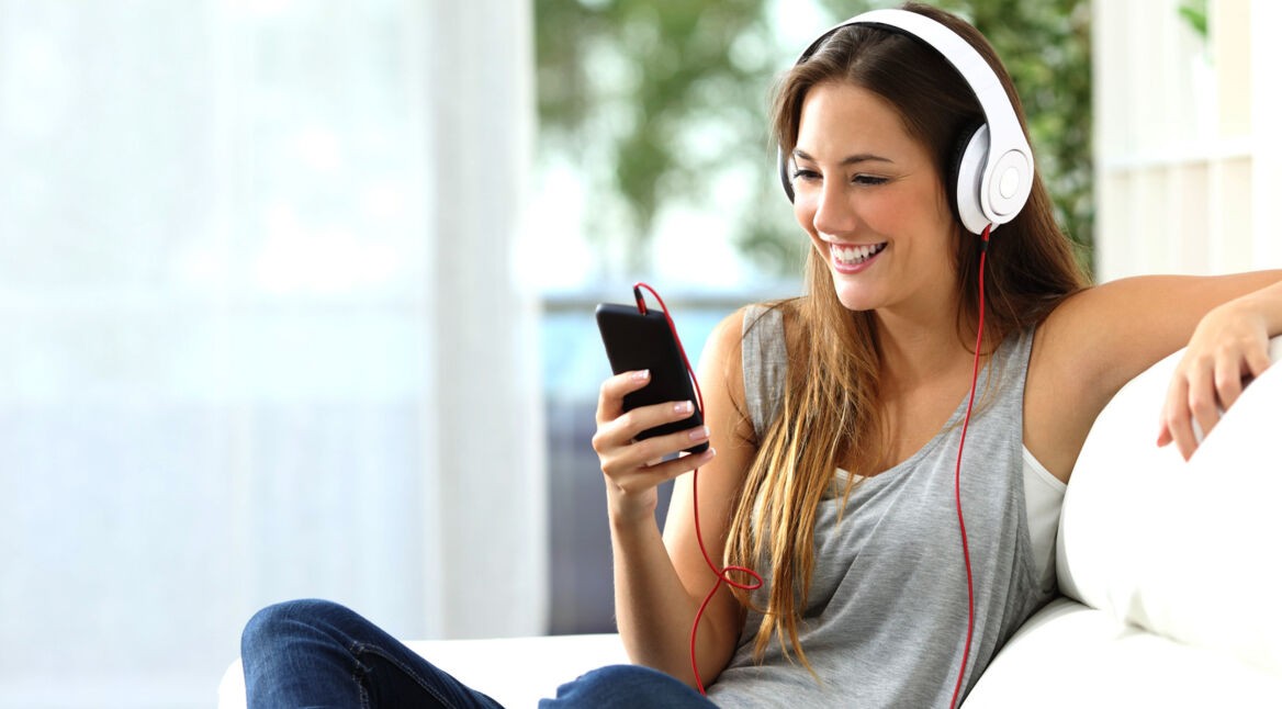 Junge Frau hört Musik auf einem Over-Ear-Kopfhörer