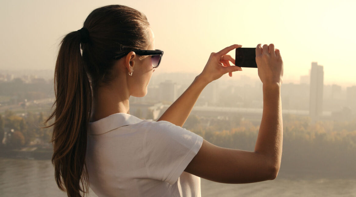 Frau nimmt Panoramabild mit Smartphone auf