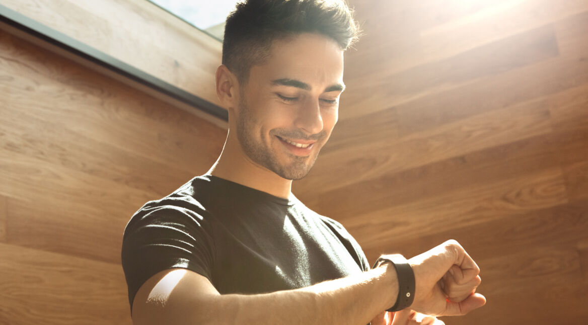 Ein Mann schaut auf seine Sportuhr