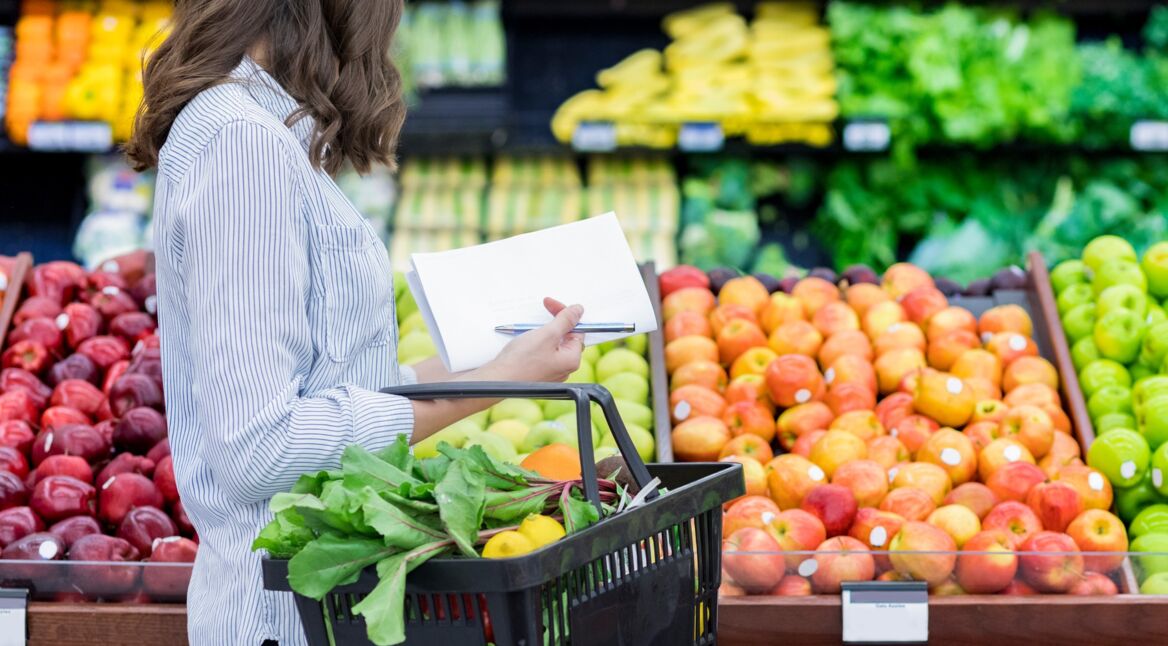 Eine junge Frau geht mit einer Liste einkaufen