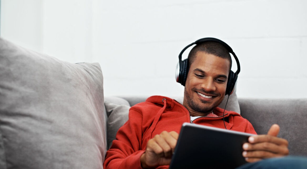 Junger Mann schaut am Tablet Amazon Prime-Serien.