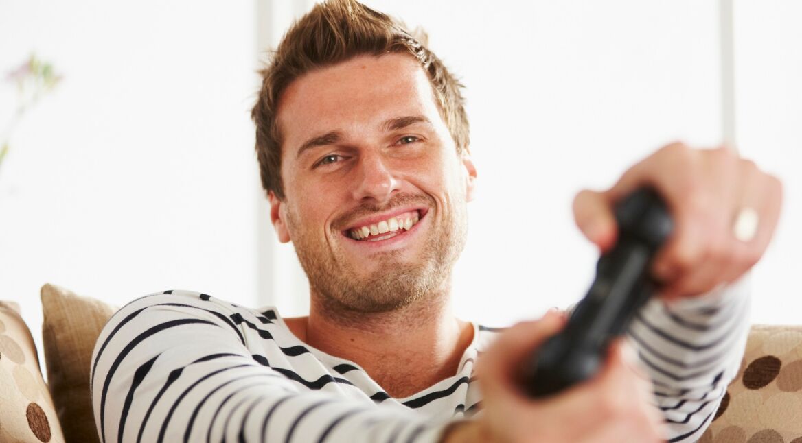 Ein junger Mann spielt PlayStation 4