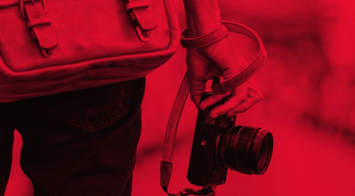 Ein junger Mann geht mit seiner Kamera spazieren